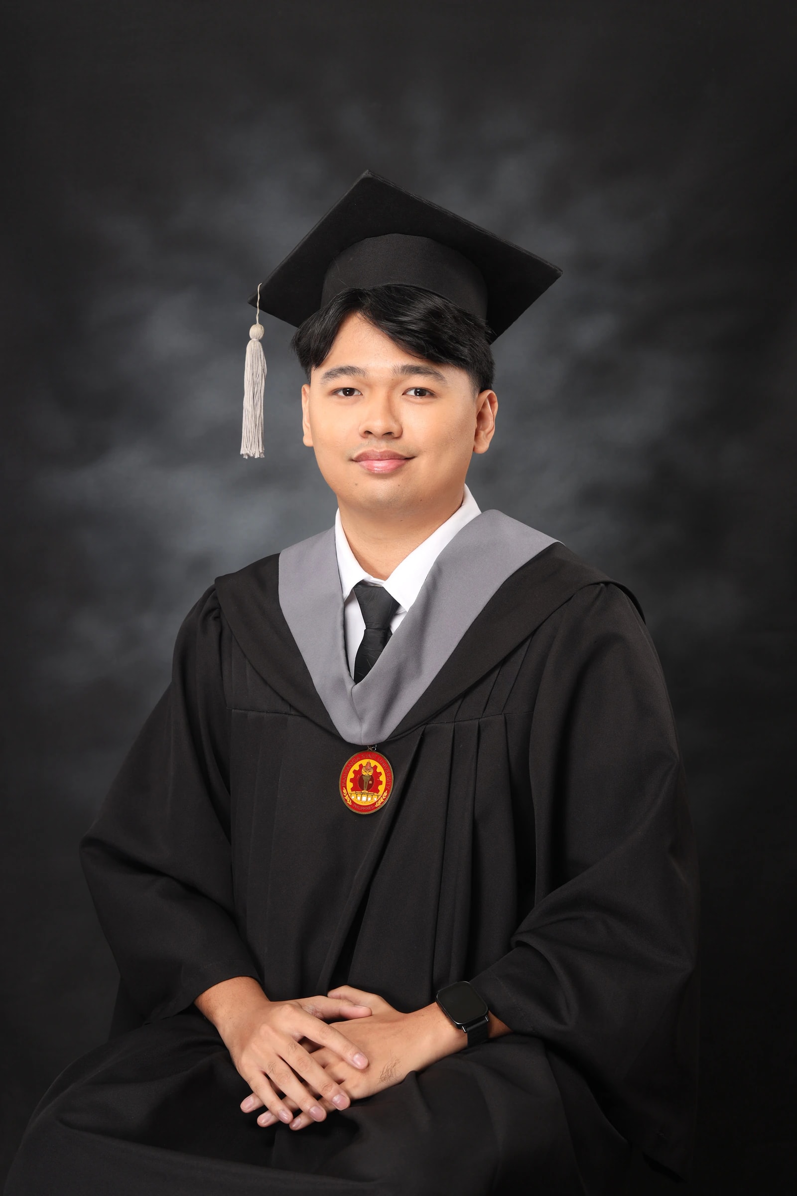Francis Emil M. Cortez in graduation cap and gown with the Pampanga State University medallion